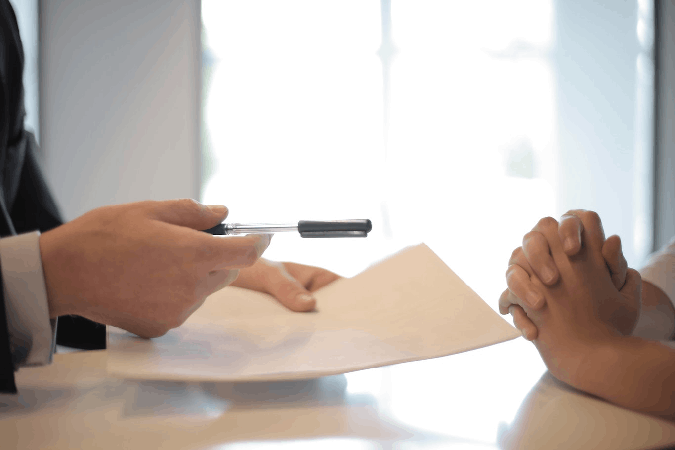 Hand holding a pen above a contract - Financing solutions
